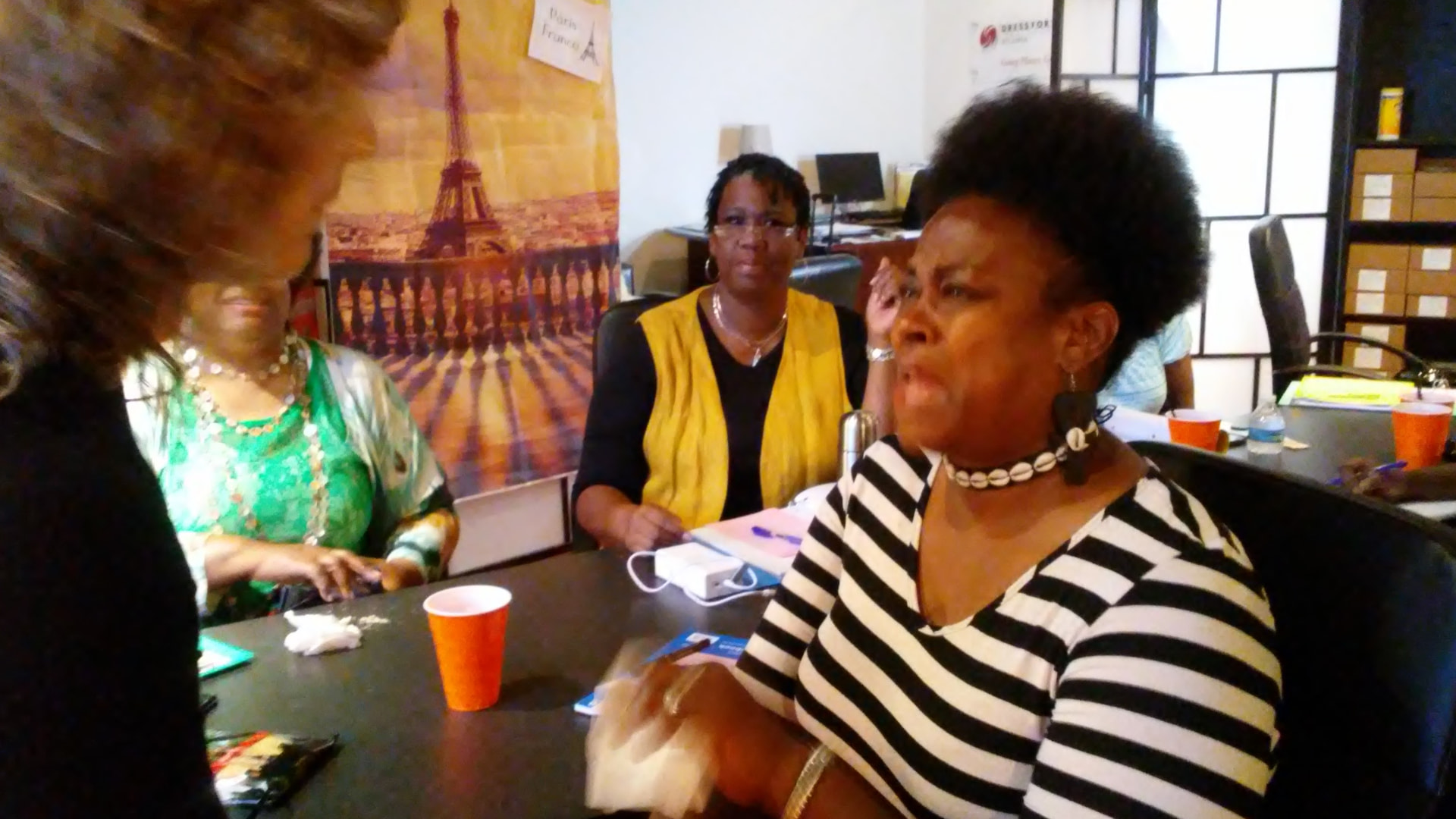 Two women in conversation around a workshop table