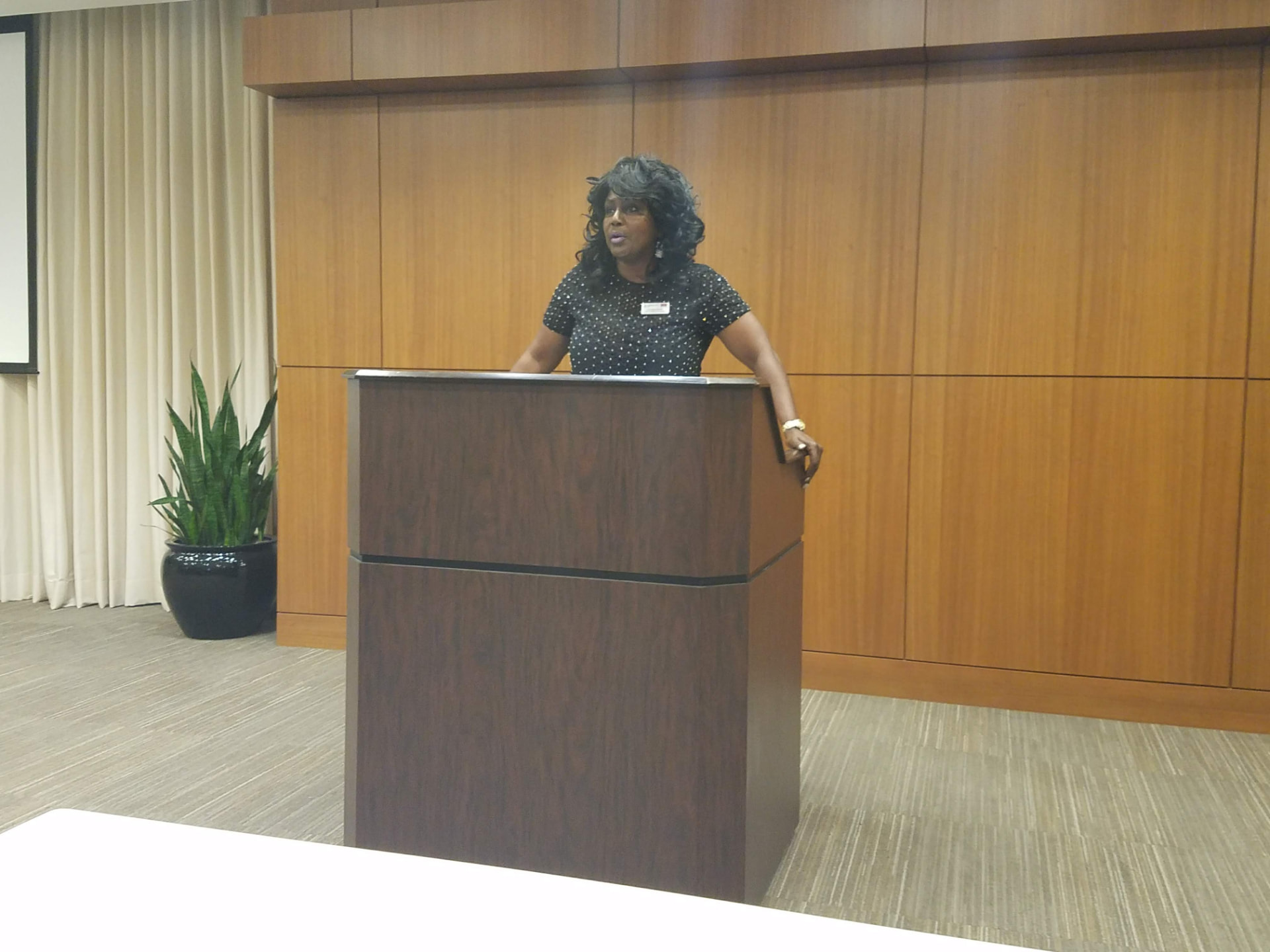 A keynote speaker at the podium in a conference room