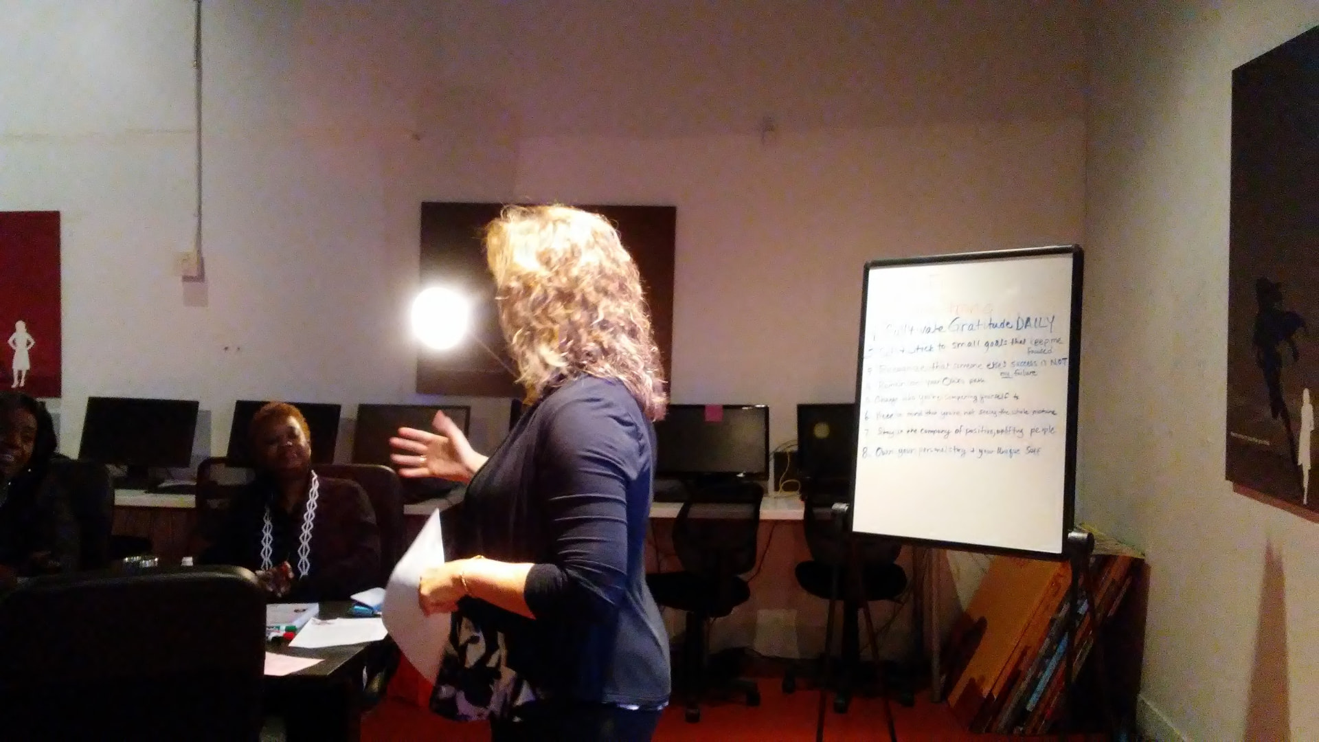 A facilitator teaching by a whiteboard listing gratitude habits